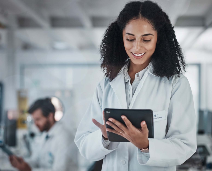 Science, research and black woman with tablet, smile and internet in laboratory with medical data. Healthcare, pharmaceutical innovation and scientist, technology and reading email